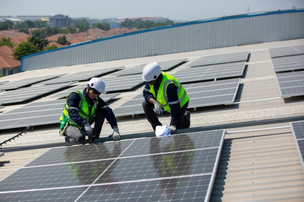 Solar panel installer installing solar panels on roof